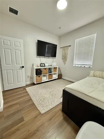 a living room with a bed furniture and a flat screen tv