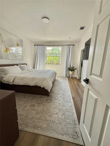 a bed sitting in a bedroom next to a window