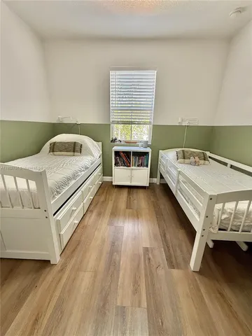a view of a bedroom with a bed and a window