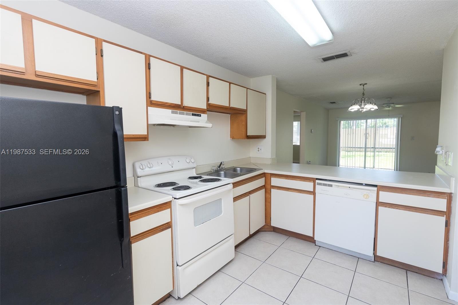 2157 Southwest 80th Terrace, Unit 2157 Miramar, FL 33025 - Photo 3 of 29 a kitchen with white cabinets and white appliances