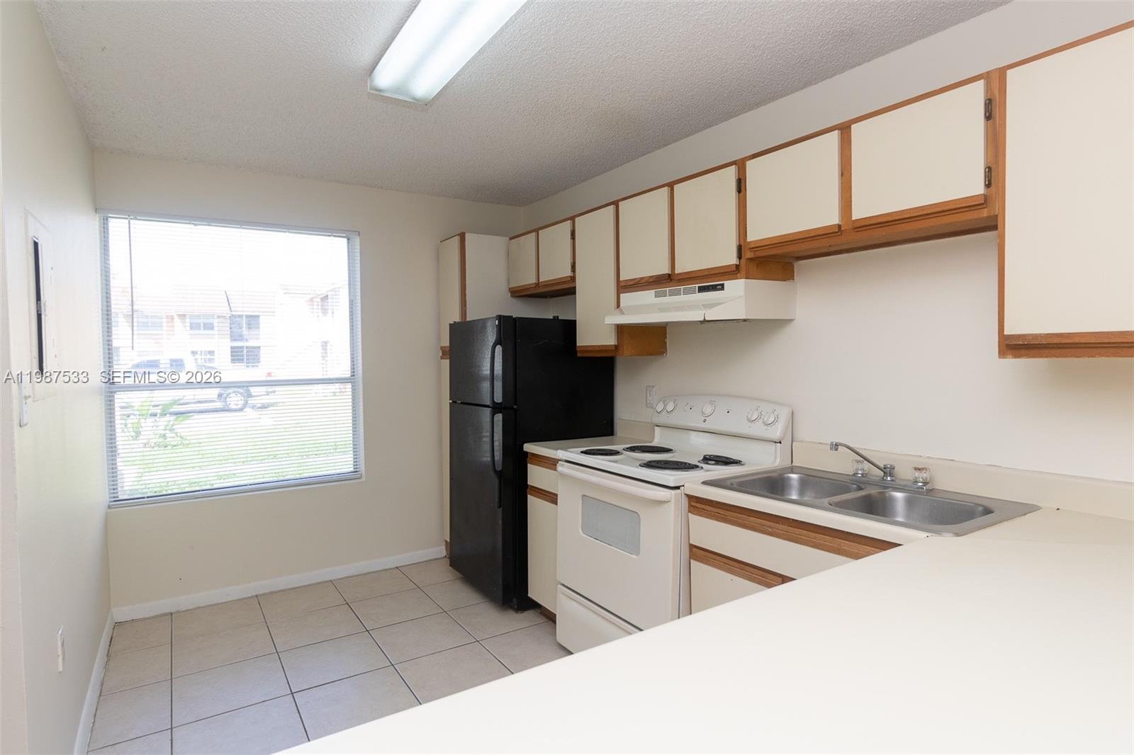 2157 Southwest 80th Terrace, Unit 2157 Miramar, FL 33025 - Photo 4 of 29 a kitchen with stainless steel appliances granite countertop a sink a stove a refrigerator cabinets and a window