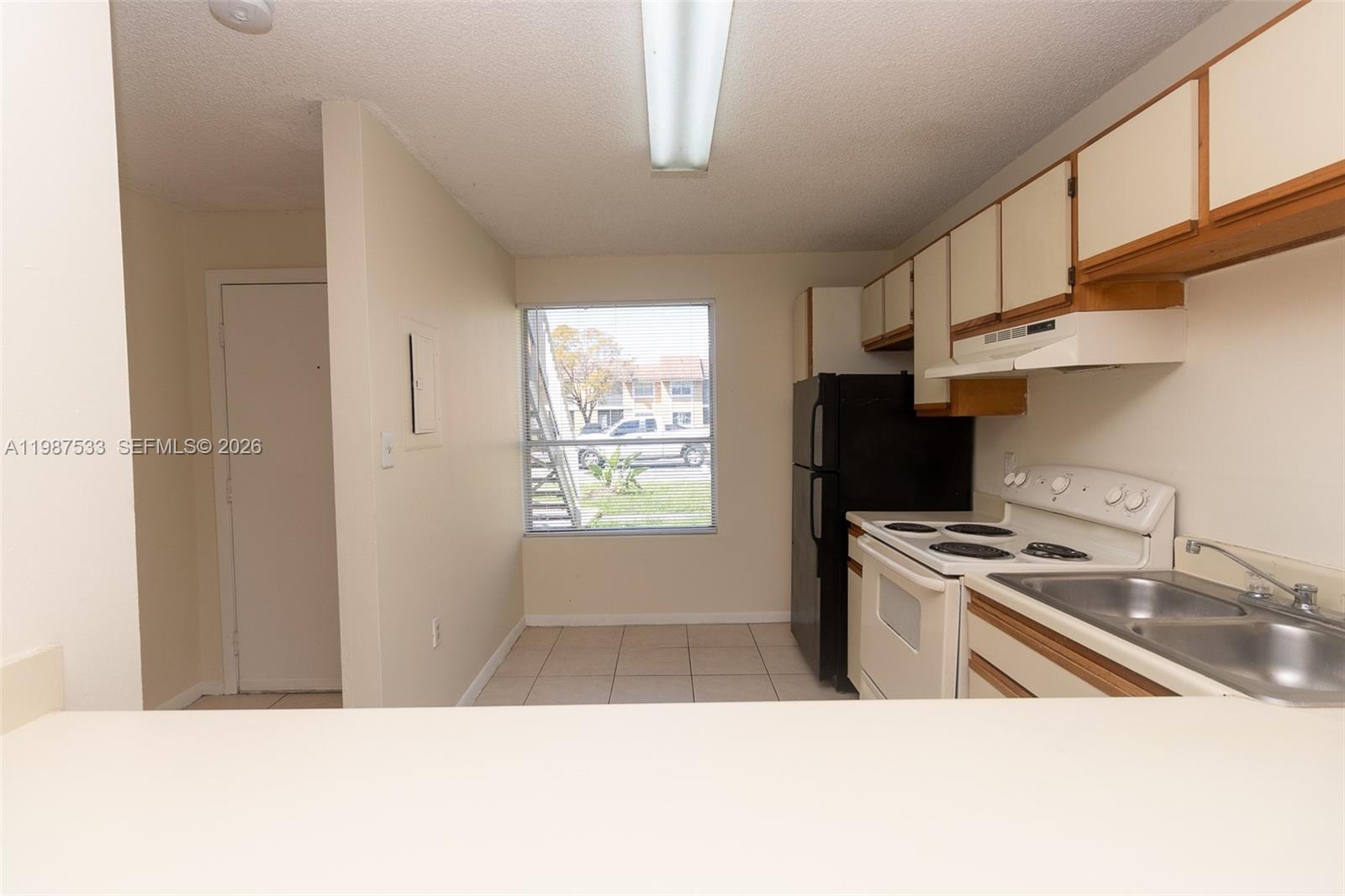 2157 Southwest 80th Terrace, Unit 2157 Miramar, FL 33025 - Photo 6 of 29 a kitchen with stainless steel appliances granite countertop a sink a stove a refrigerator cabinets and a window