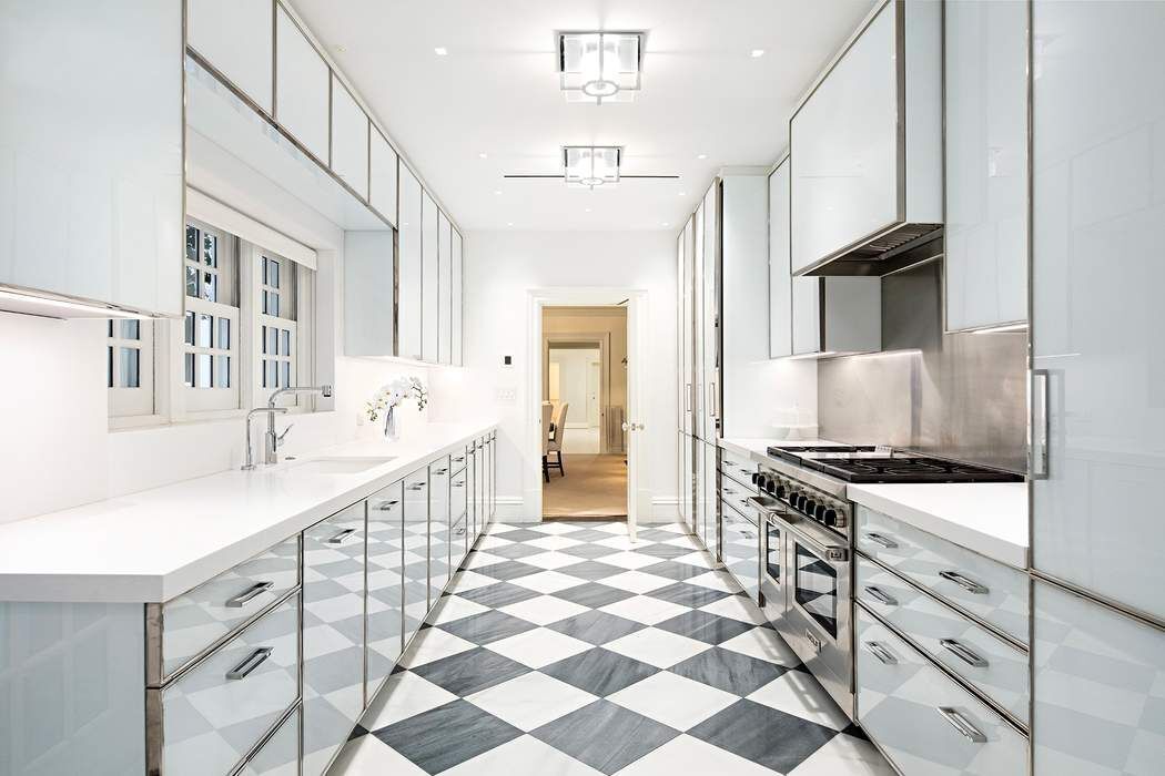 10 East 73rd Street Manhattan, NY 10021 - Photo 5 of 16 a kitchen with stainless steel appliances a stove a sink and a refrigerator