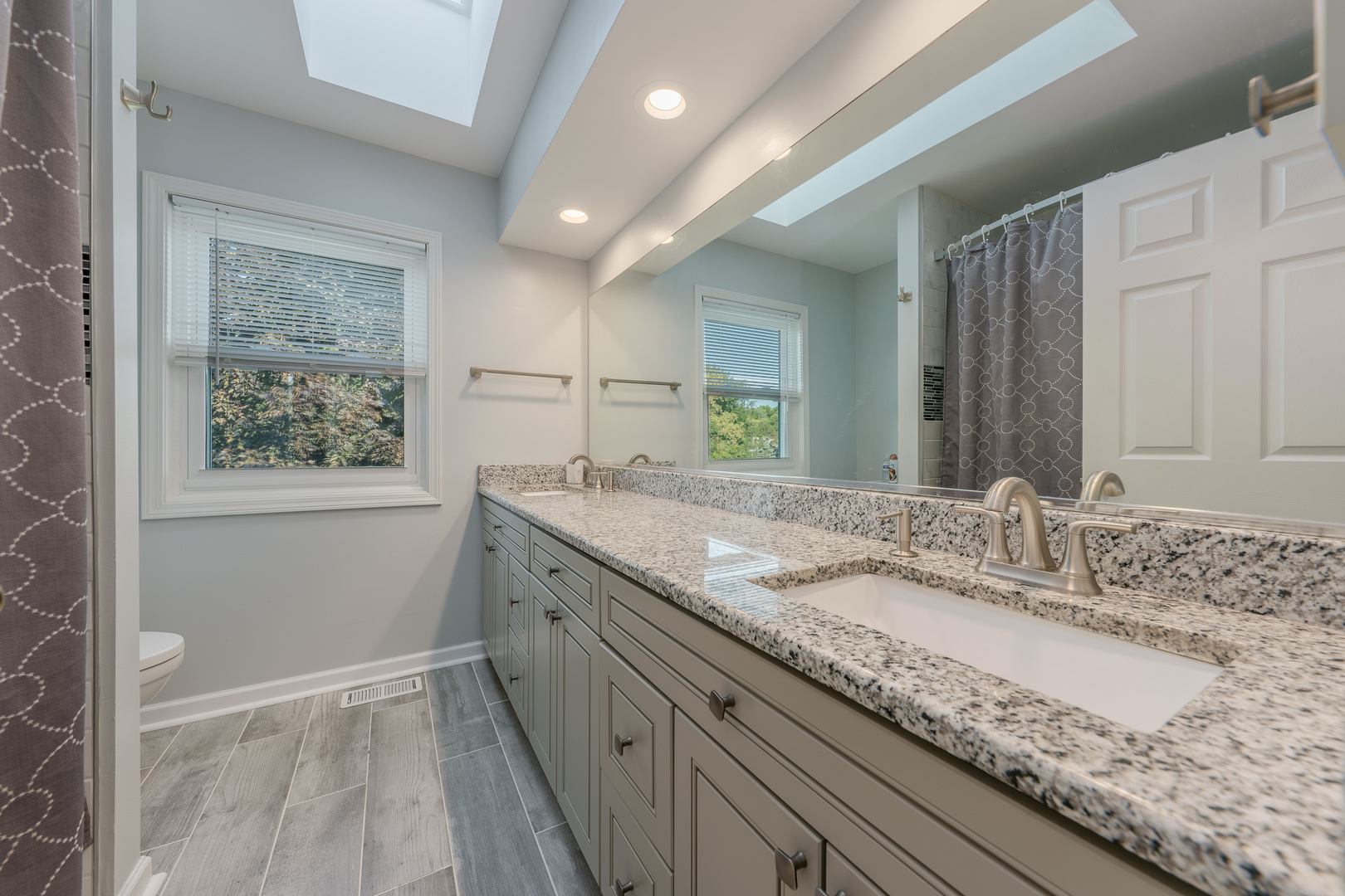 113 Bittersweet Lane Streamwood, IL 60107 - Photo 17 of 24 a bathroom with a granite countertop sink a large mirror a and a window