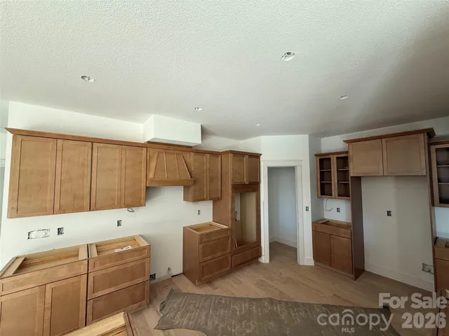 a living room with stainless steel appliances furniture a flat screen tv and a refrigerator
