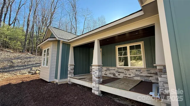 a living room with stainless steel appliances furniture a flat screen tv and a refrigerator