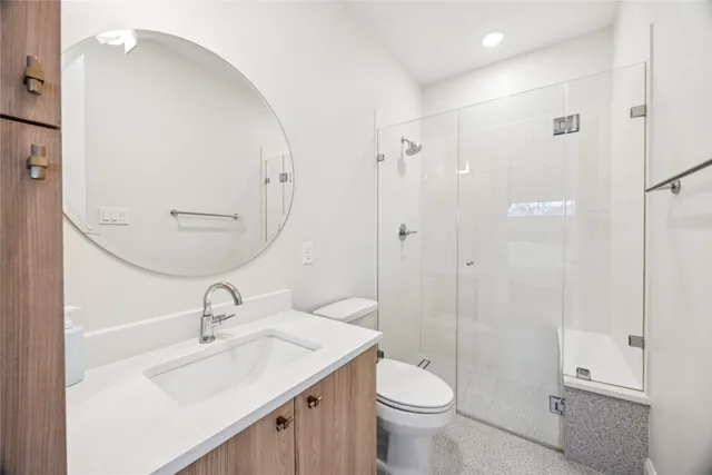 a bathroom with a sink toilet a mirror and shower