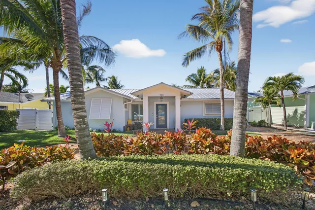 a front view of a house with a yard and potted plants