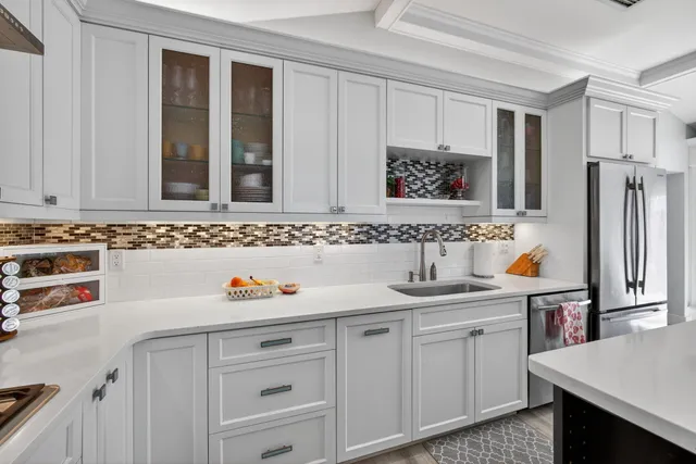 a kitchen with granite countertop a sink cabinets and wooden floor