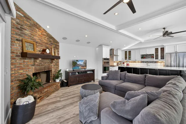 a kitchen with stainless steel appliances kitchen island granite countertop a table chairs in it and wooden floors