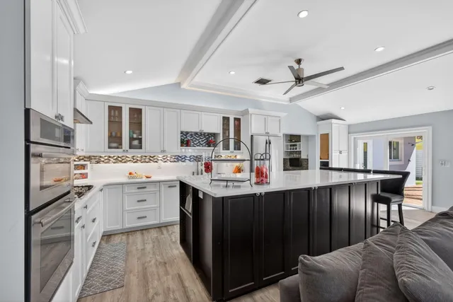 a kitchen with stainless steel appliances white cabinets and a window