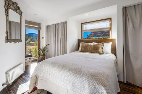 a view of a dining room with furniture large windows and wooden floor