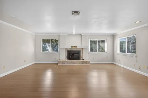 an empty room with windows and a fireplace