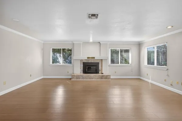 an empty room with windows and a fireplace