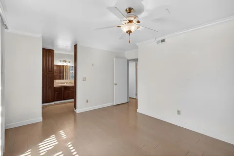 a view of an empty room with a chandelier fan