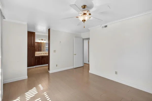 a view of an empty room with a chandelier fan