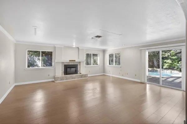 a view of empty room with wooden floor and fireplace