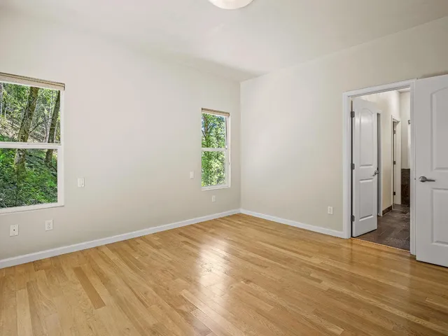 a bedroom with a bed a painting and a large window