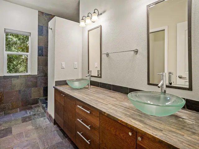 a bathroom with a granite countertop sink a toilet and shower