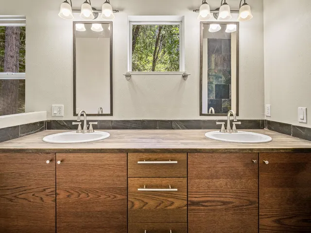 a bathroom with a granite countertop sink a mirror and a shower