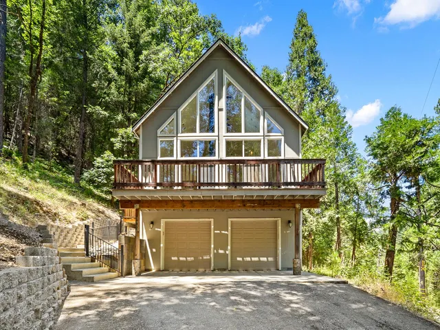 a front view of a house with a yard and trees