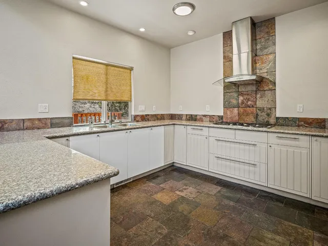 a kitchen with a sink a window and cabinets
