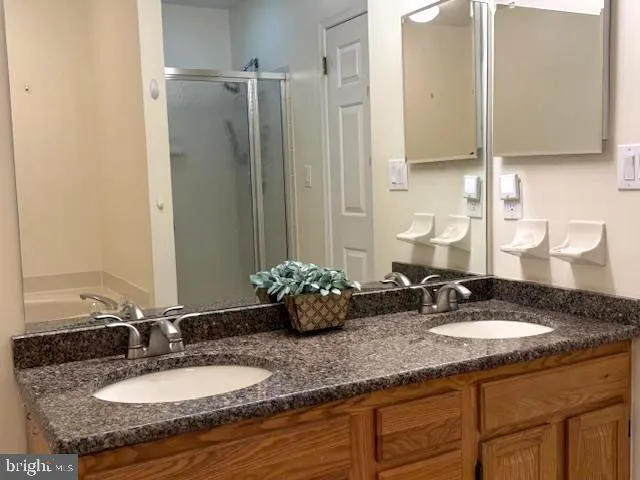 a bathroom with double vanity sinks and a mirror