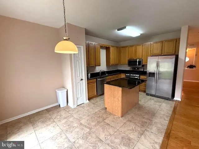 a kitchen with stainless steel appliances granite countertop a refrigerator a stove a sink dishwasher and a refrigerator