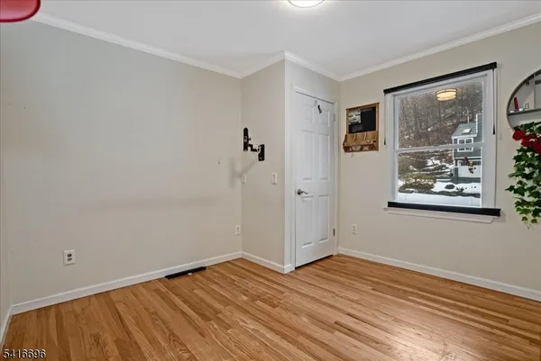 a view of a room with wooden floor and window