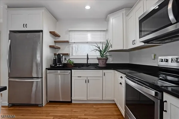 a kitchen with appliances a sink and a refrigerator