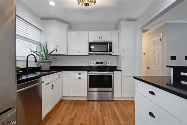 a kitchen with appliances a sink and cabinets