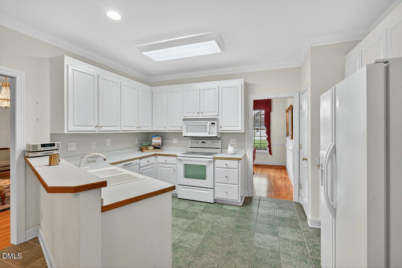 2204 Hayfield Drive Durham, NC 27705 - Photo 18 of 56 a kitchen with stainless steel appliances granite countertop a refrigerator sink and white cabinets