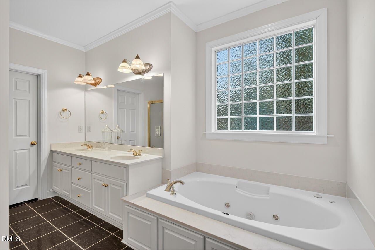 2204 Hayfield Drive Durham, NC 27705 - Photo 24 of 56 a bathroom with a tub sink and a mirror