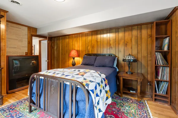 a bedroom with a bed and wooden floor