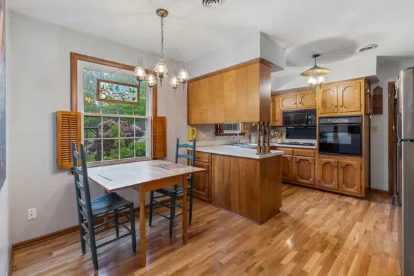 a kitchen with stainless steel appliances wooden floor dining table and chairs