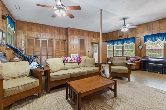 a living room with furniture a ceiling fan and a window