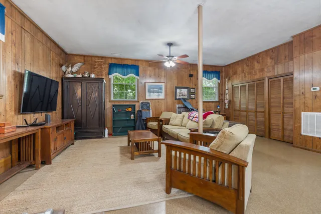 a living room with furniture a flat screen tv and a large window