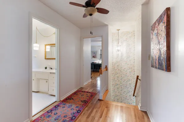 a view of a hallway view with wooden floor and a bathroom