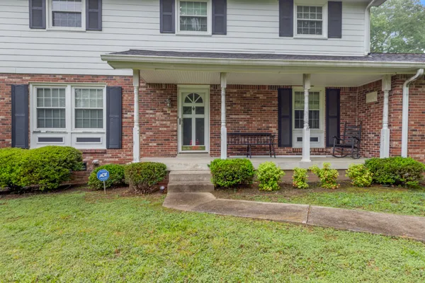 a front view of a house with garden and porch
