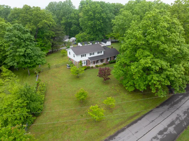 a aerial view of a house with a big yard and large trees