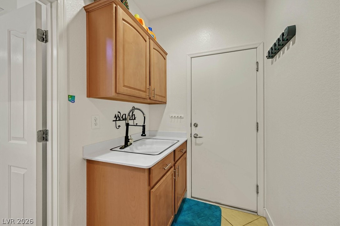 2228 Waterton Rivers Drive Henderson, NV 89044 - Photo 27 of 57 Laundry Room with Cabinets and Large Sink. Door into Garage.