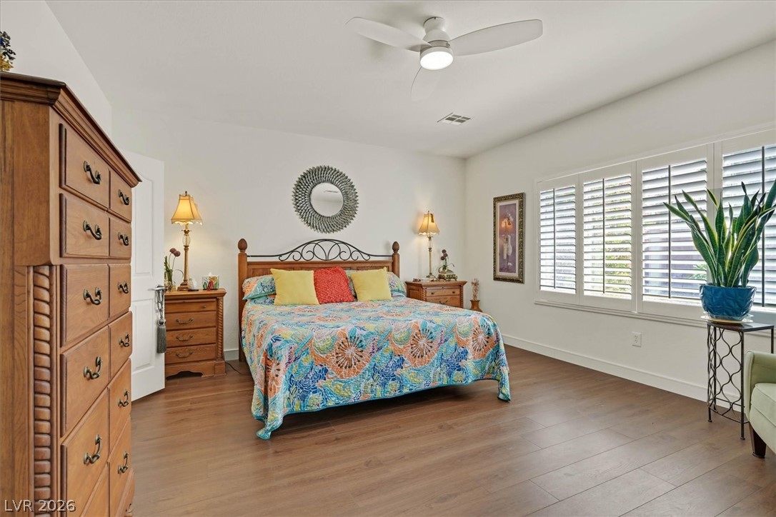 2228 Waterton Rivers Drive Henderson, NV 89044 - Photo 32 of 57 Primary Bedroom with Beautiful Wide Plank Engineered Hardwood Floors, Custom Shutters and new Ceiling Fan.