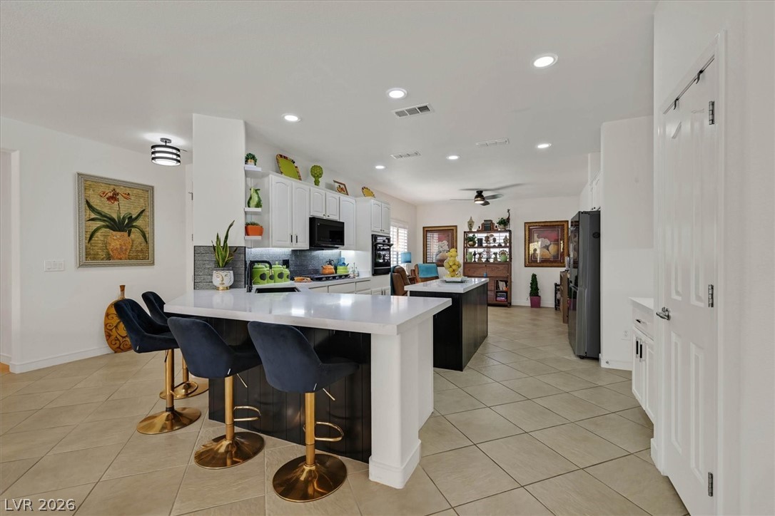 2228 Waterton Rivers Drive Henderson, NV 89044 - Photo 5 of 57 Beautiful Kitchen. Special multi functional recessed lighting, Quartz counters and wood accents on breakfast bar area and Island.