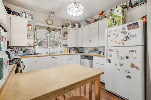 a kitchen with white cabinets and refrigerator