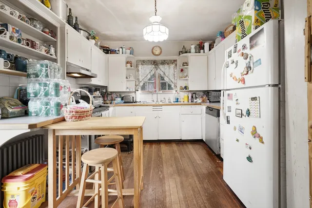 a kitchen with furniture a refrigerator and wooden floor
