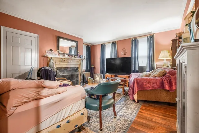 a bedroom with furniture a flat screen tv and a fireplace