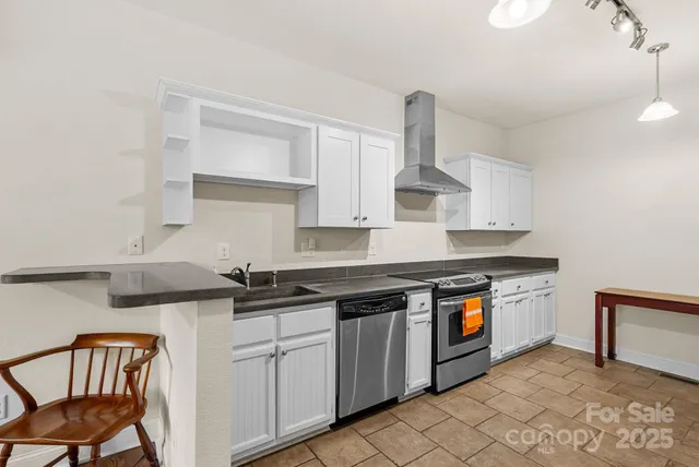 a kitchen with stainless steel appliances granite countertop a sink stove and cabinets