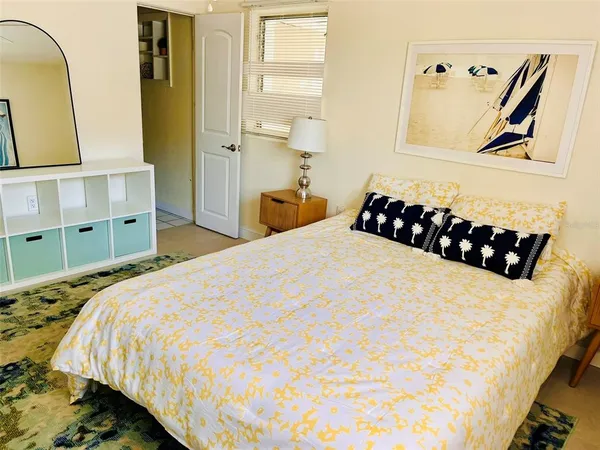 a bedroom with a bed and painting on the wall