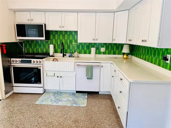a kitchen with stainless steel appliances a stove a microwave and cabinets