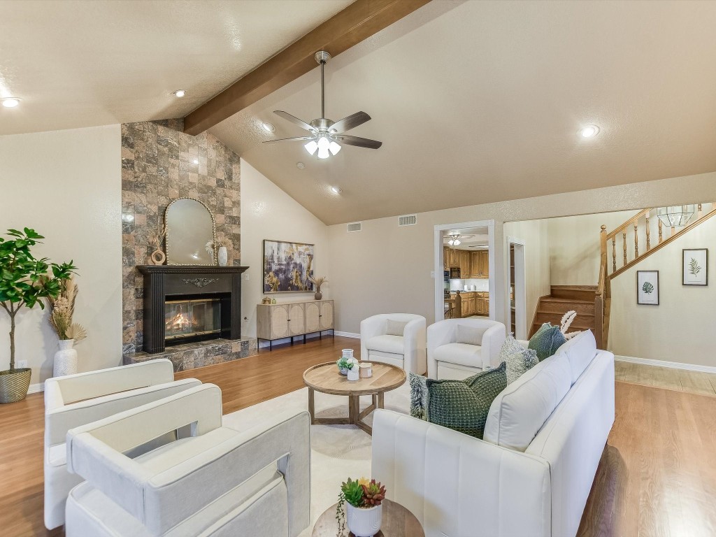 a living room with furniture a fireplace and a chandelier